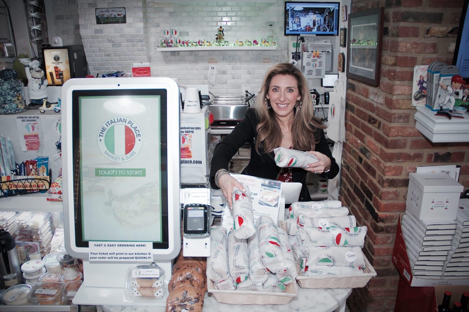 The Italian Place register and founder with sandwiches