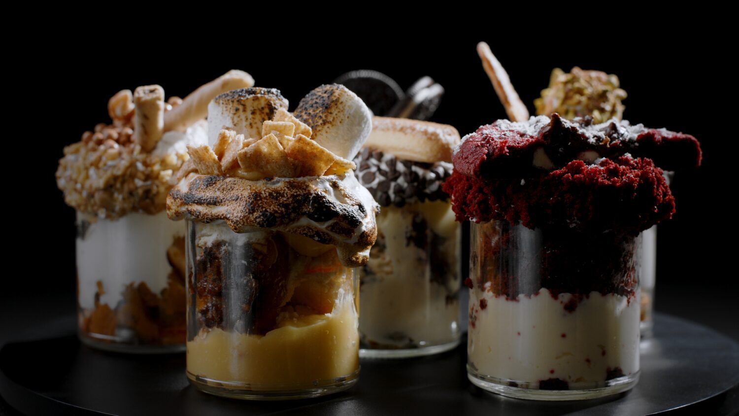 Close up of various types of desserts in jars