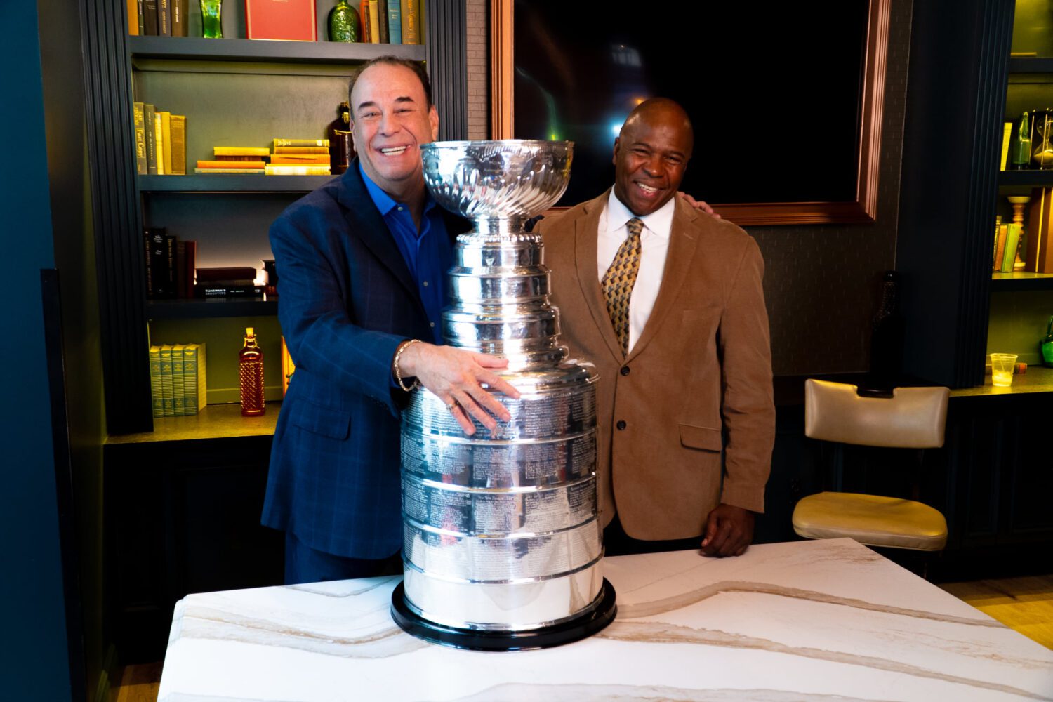 Jon Taffer and another gentleman standing with a large stanley cup on table