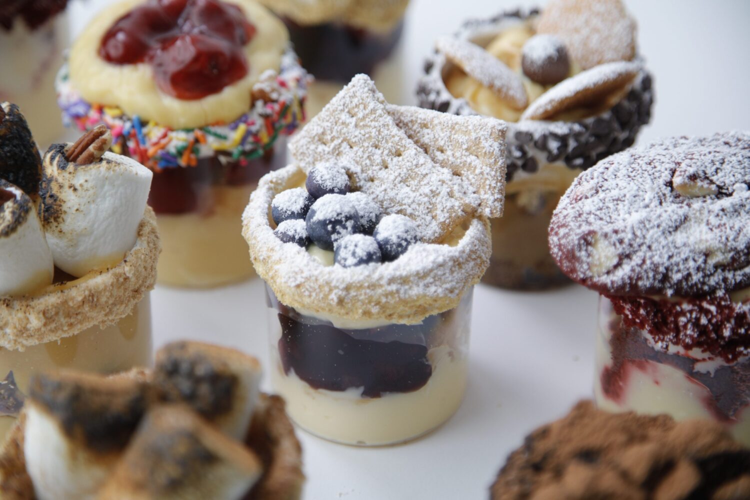 Jars of desserts topped with delicious dessert toppings