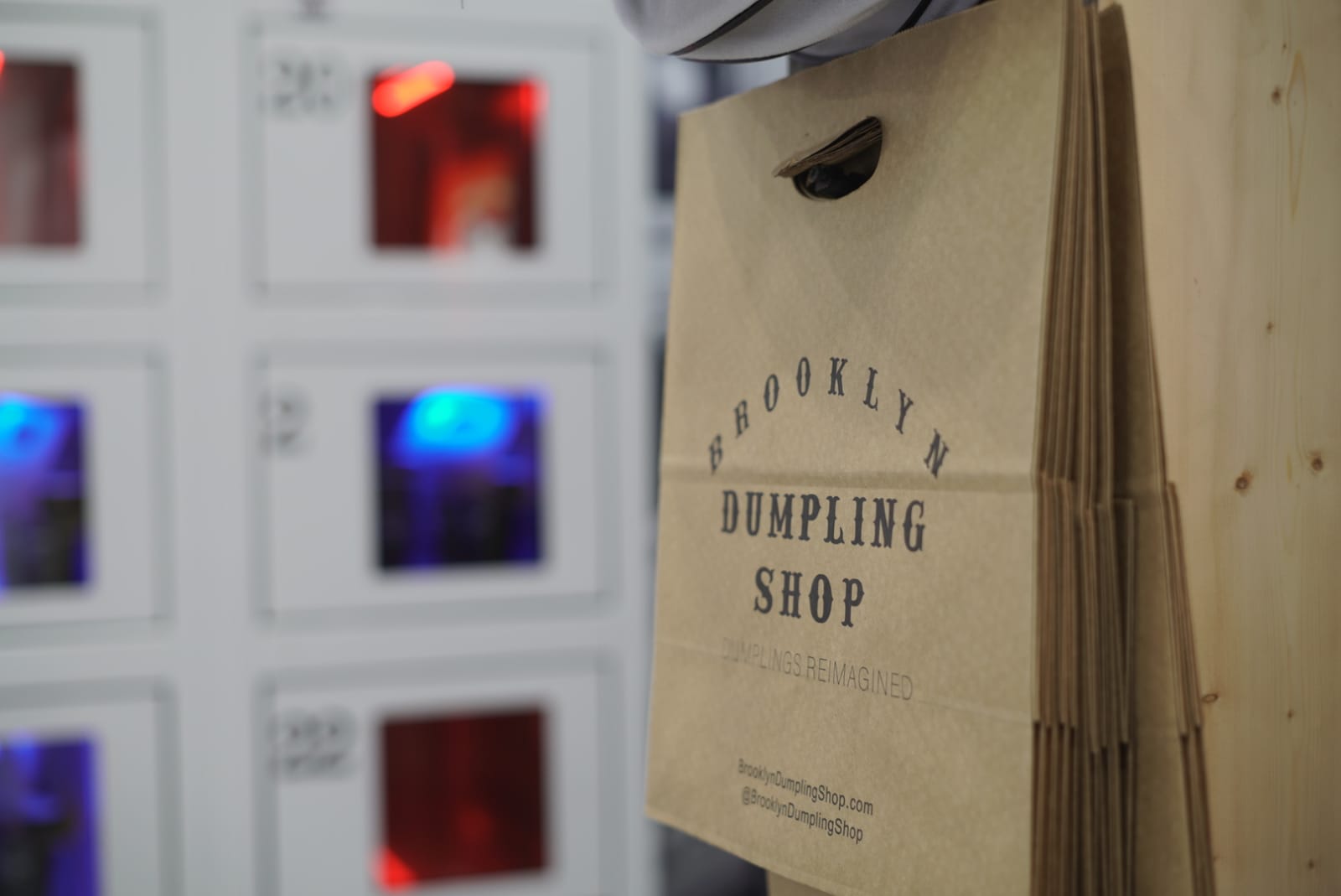 Brooklyn Dumpling Shop bag in front of automat in restaurant.