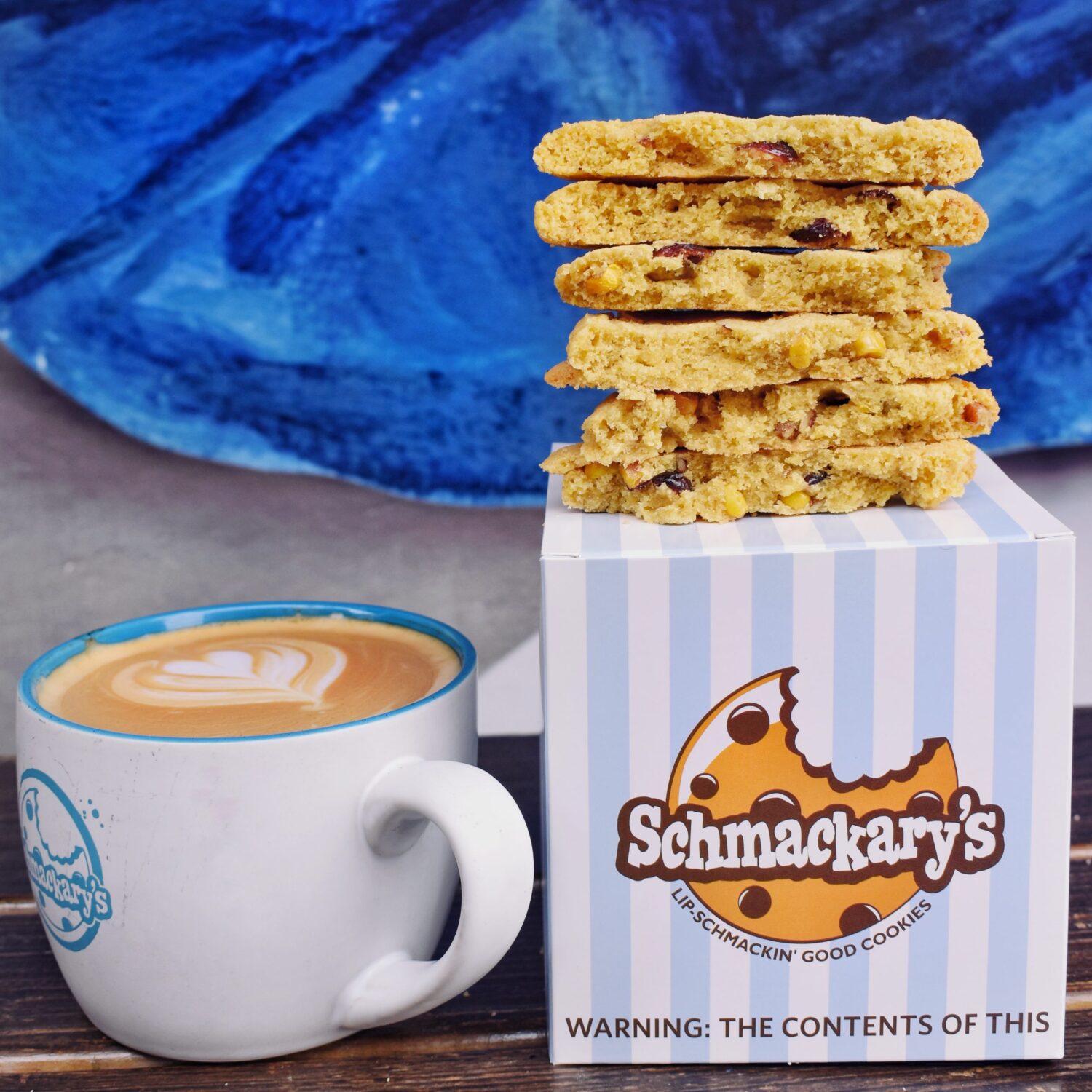 Schmackary's cookies franchise logo + picture of coffee cup next to box of cookies