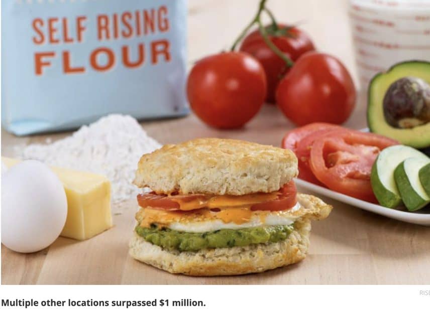 Biscuit sandwich on table with tomatoes in background